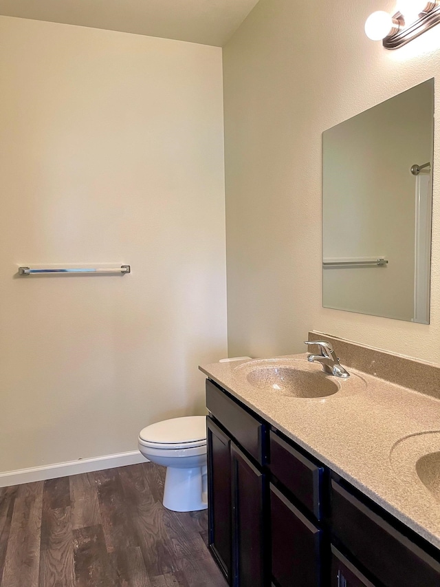 bathroom featuring wood-type flooring, vanity, and toilet