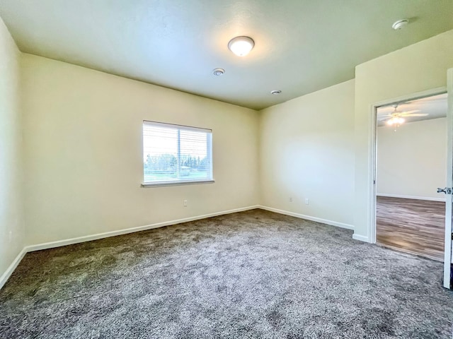 carpeted spare room featuring ceiling fan