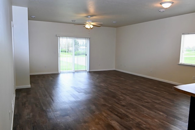 spare room with plenty of natural light, ceiling fan, and dark hardwood / wood-style flooring