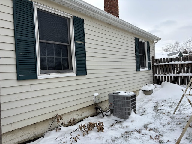 1107 SE 2nd St, Minot, ND 58701 - view of snow covered exterior featuring cooling unit and a chimney