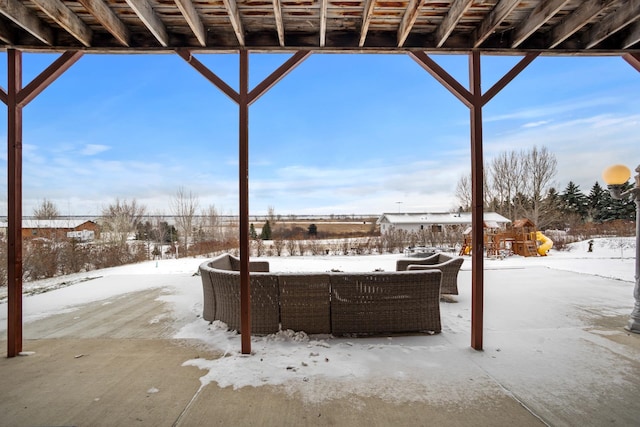 snow covered patio with a playground