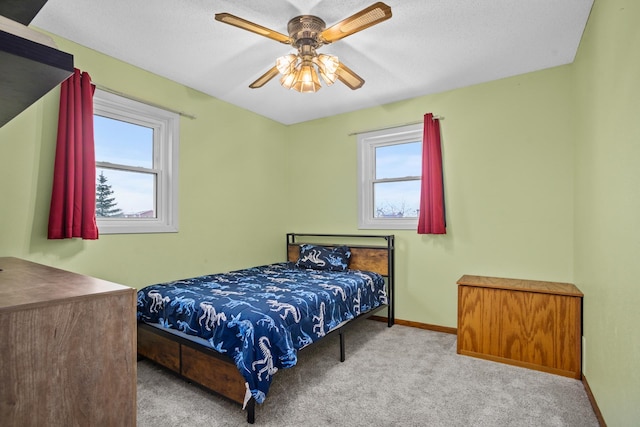 carpeted bedroom featuring a textured ceiling, multiple windows, and ceiling fan