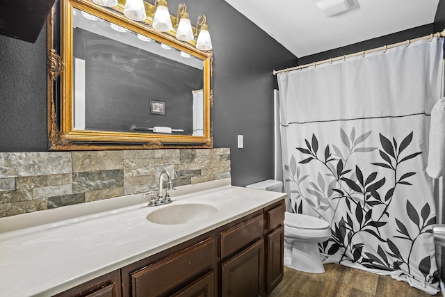 bathroom featuring decorative backsplash, vanity, hardwood / wood-style flooring, and toilet