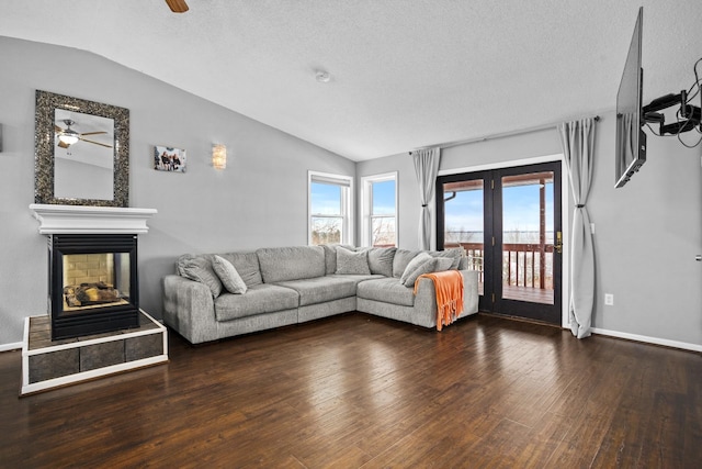 living room featuring a textured ceiling, dark hardwood / wood-style floors, vaulted ceiling, and ceiling fan