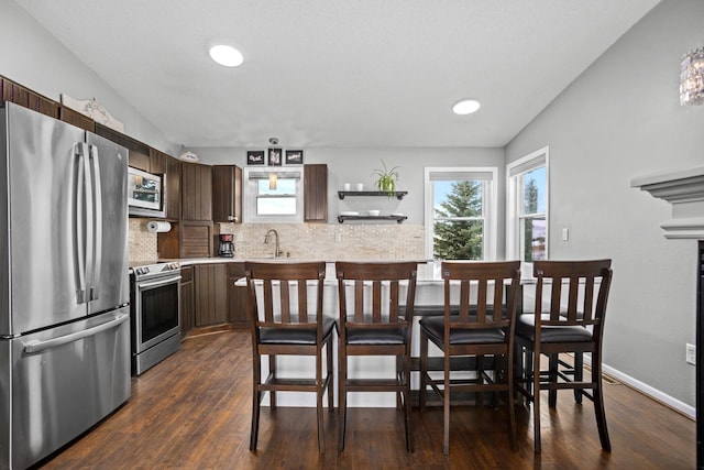 kitchen with backsplash, sink, vaulted ceiling, dark hardwood / wood-style floors, and stainless steel appliances