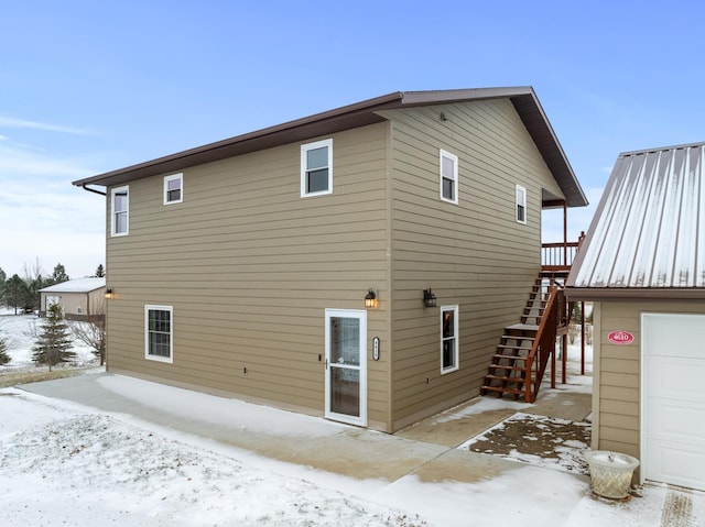 snow covered house featuring a garage