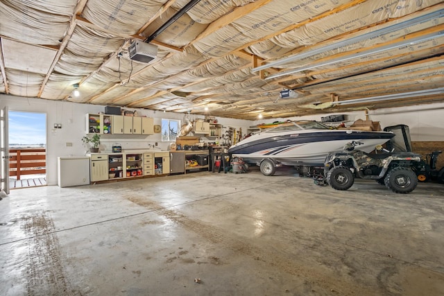 garage with a workshop area, a garage door opener, and fridge