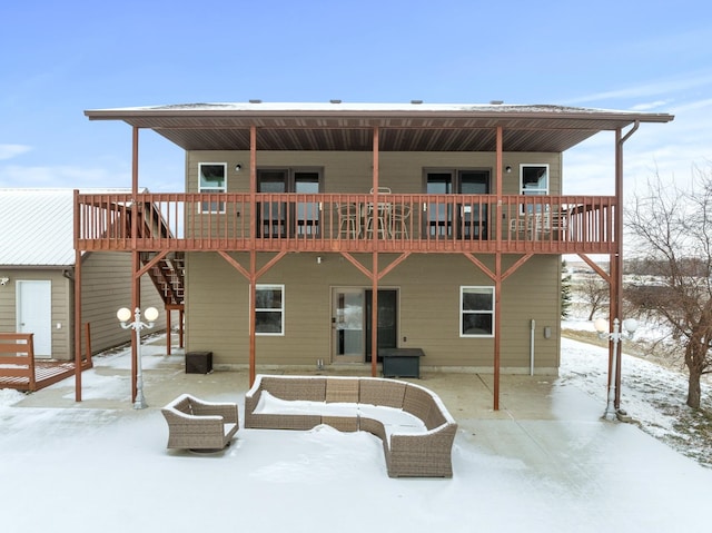 snow covered back of property with a wooden deck