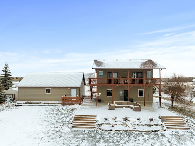 snow covered back of property featuring a deck