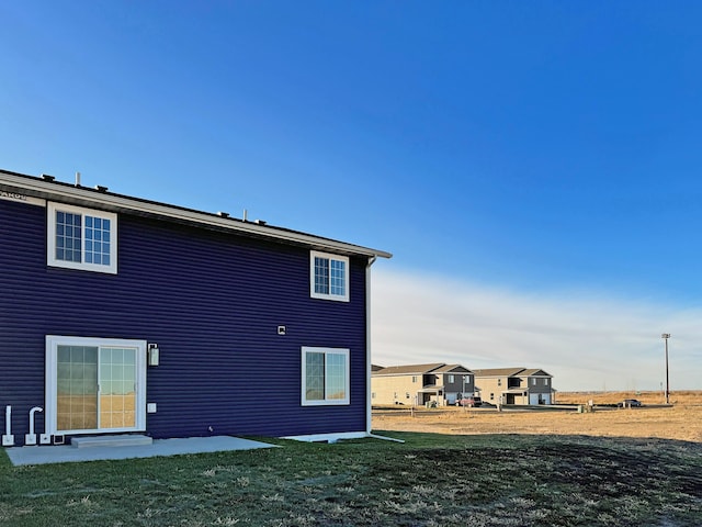3308 23rd Ave NW, Minot, ND 58703 - back of property with a patio and a lawn