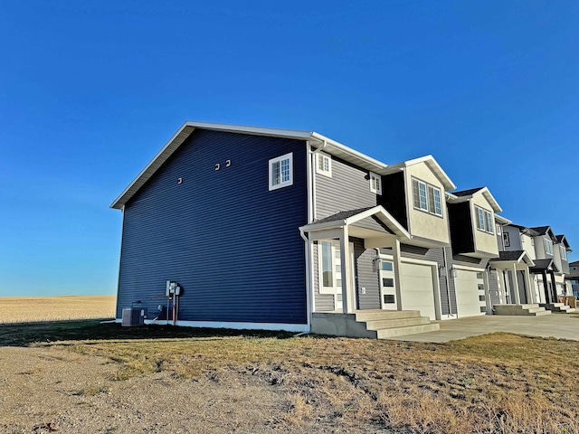3308 23rd Ave NW, Minot, ND 58703 - view of side of home featuring central AC and a garage