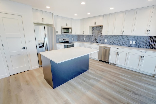 3308 23rd Ave NW, Minot, ND 58703 - kitchen featuring white cabinets, light wood-type flooring, stainless steel appliances, and sink