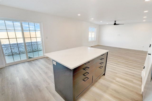 3308 23rd Ave NW, Minot, ND 58703 - kitchen with light hardwood / wood-style flooring, a kitchen island, and ceiling fan