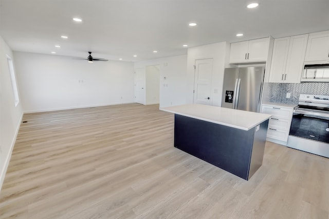 3308 23rd Ave NW, Minot, ND 58703 - kitchen featuring ceiling fan, a center island, stainless steel appliances, light hardwood / wood-style floors, and white cabinets