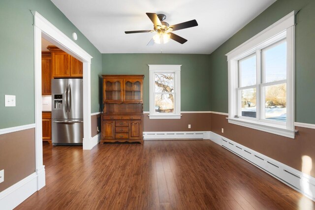 423 1st Ave, Kenmare, ND 58746 - interior space featuring ceiling fan, dark wood-type flooring, and a baseboard heating unit