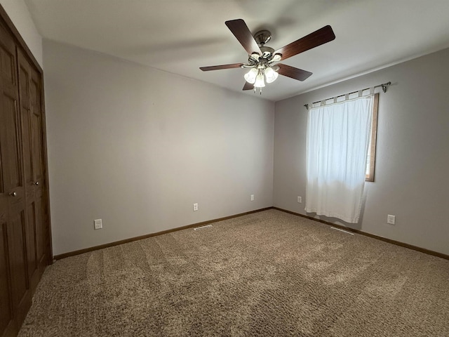 carpeted empty room featuring ceiling fan