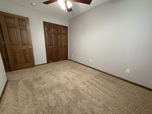 unfurnished bedroom with ceiling fan, a closet, and carpet floors