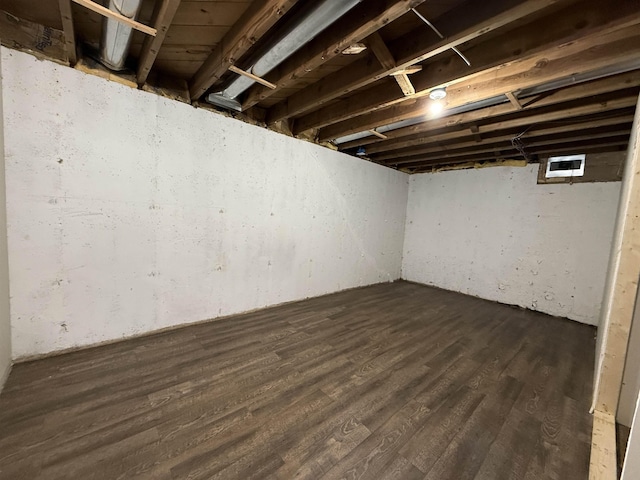 basement with dark hardwood / wood-style floors