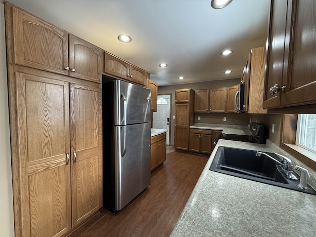 kitchen featuring appliances with stainless steel finishes, dark wood-type flooring, and sink