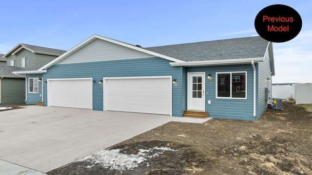 view of front of home with a garage and central air condition unit