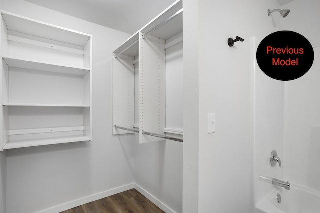 walk in closet with dark hardwood / wood-style floors