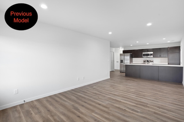 unfurnished living room featuring dark hardwood / wood-style flooring and sink