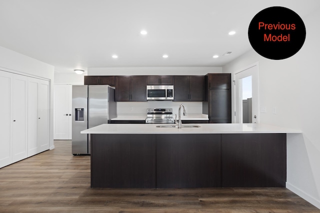 kitchen with hardwood / wood-style floors, dark brown cabinets, sink, and stainless steel appliances