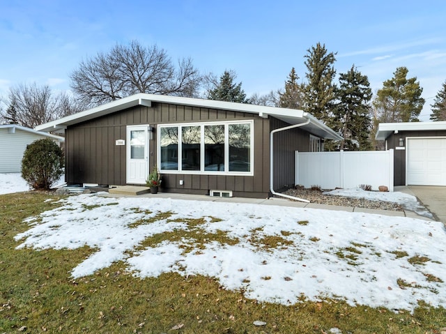 snow covered rear of property featuring an outbuilding