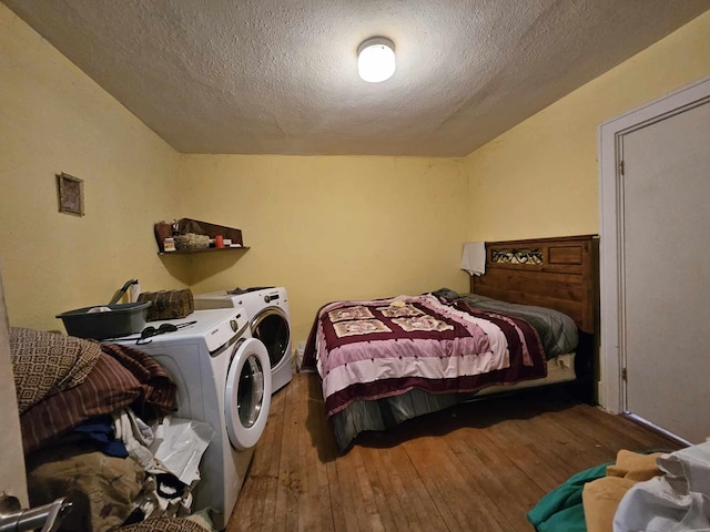 bedroom with washer and dryer, a textured ceiling, and hardwood / wood-style flooring