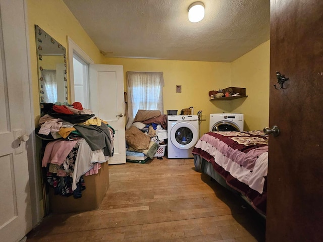 bedroom featuring washer and dryer, a textured ceiling, and light wood-type flooring