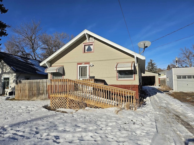 view of front facade with a wooden deck, an outdoor structure, and a garage