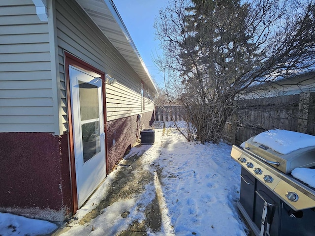 view of snow covered exterior featuring cooling unit