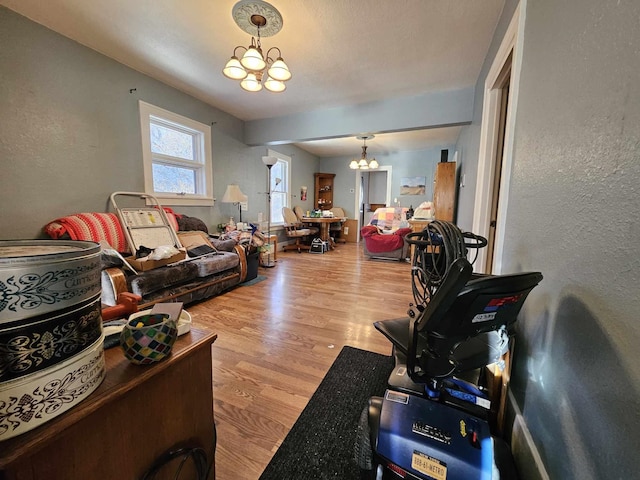 living room with light hardwood / wood-style floors and an inviting chandelier