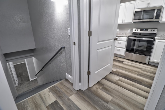 stairs featuring hardwood / wood-style floors