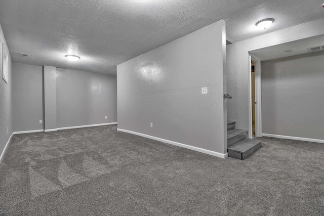 basement with dark carpet and a textured ceiling