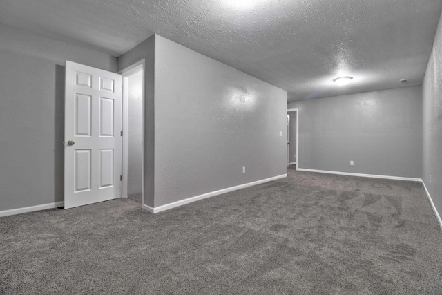 empty room featuring a textured ceiling and dark colored carpet