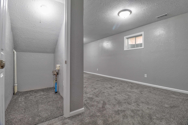 basement with dark carpet and a textured ceiling