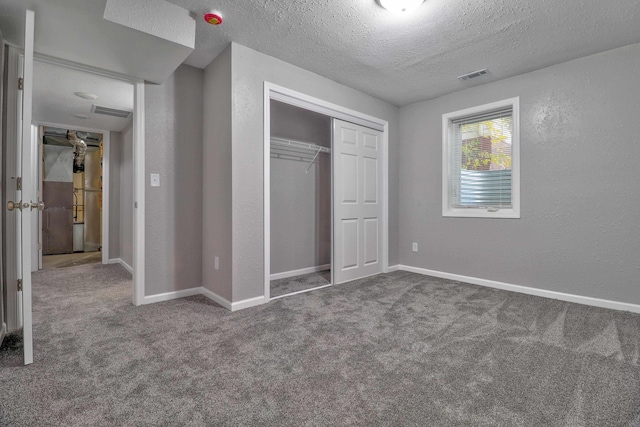 unfurnished bedroom featuring carpet flooring, a closet, and a textured ceiling