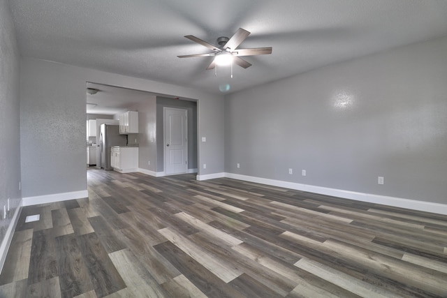 unfurnished living room with a textured ceiling, dark hardwood / wood-style floors, and ceiling fan