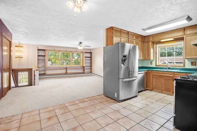 kitchen with light tile patterned floors, a textured ceiling, and stainless steel appliances