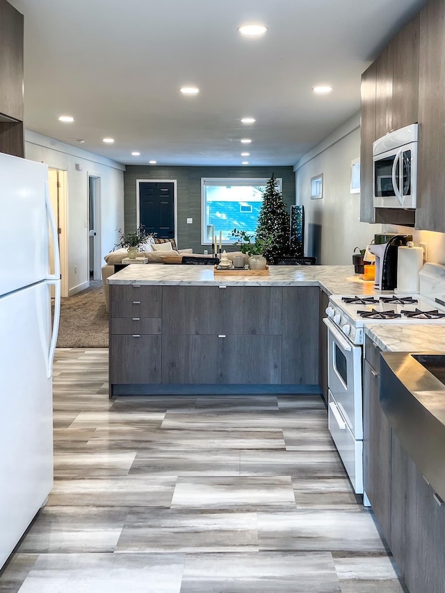 kitchen featuring white appliances and kitchen peninsula