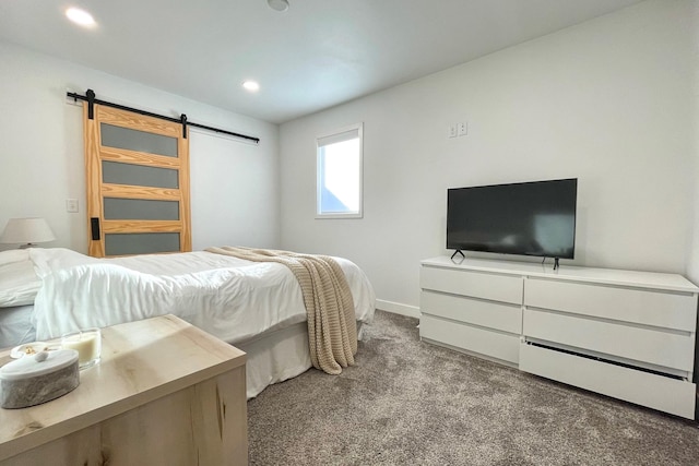 bedroom with a barn door and light carpet