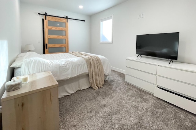 bedroom with a barn door and light colored carpet