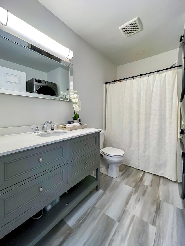 bathroom with hardwood / wood-style floors, vanity, and toilet