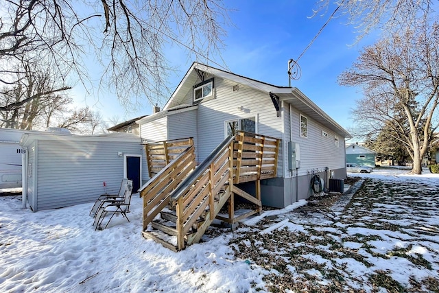 snow covered house with central air condition unit