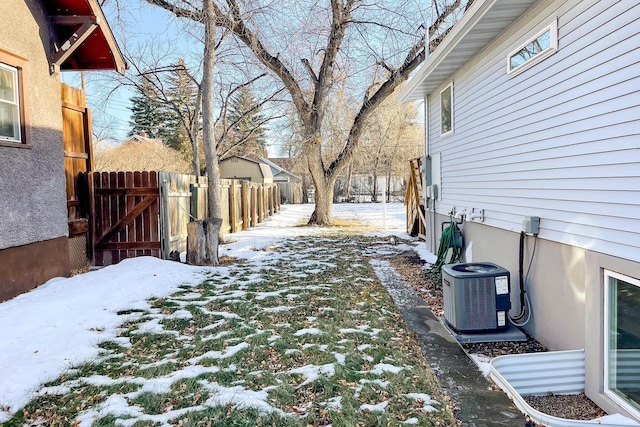 yard layered in snow with central air condition unit