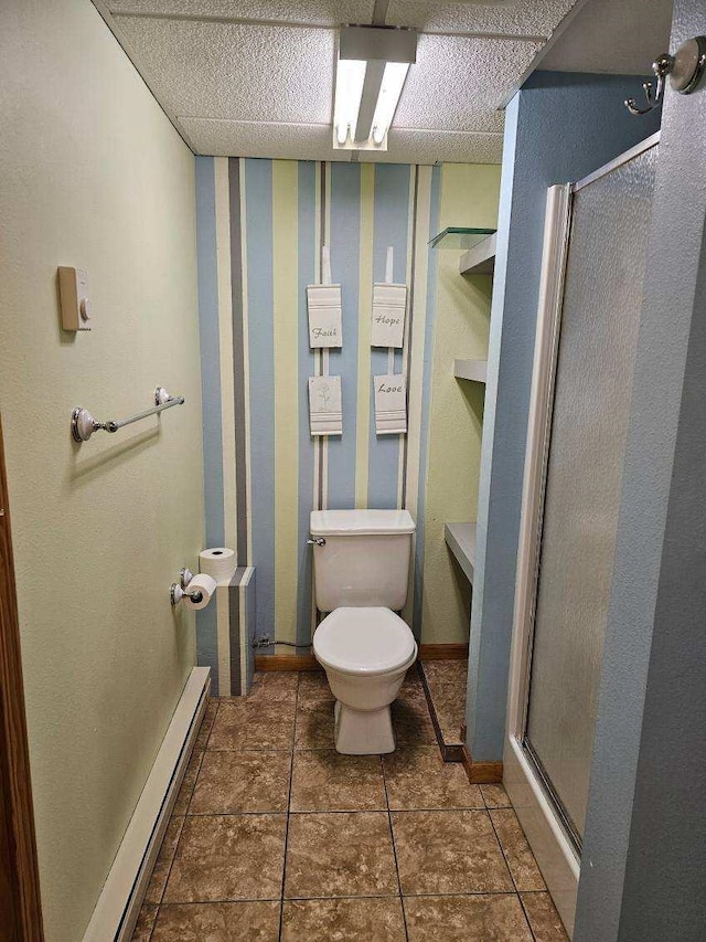 bathroom with tile patterned floors, a shower with door, a baseboard radiator, and toilet