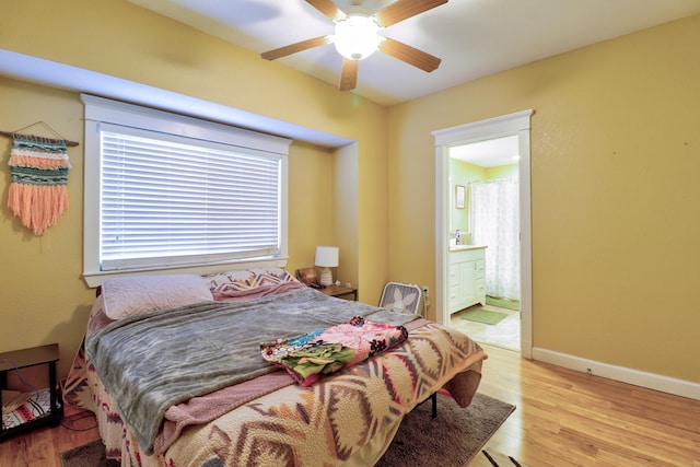 bedroom featuring ceiling fan, light hardwood / wood-style floors, and connected bathroom