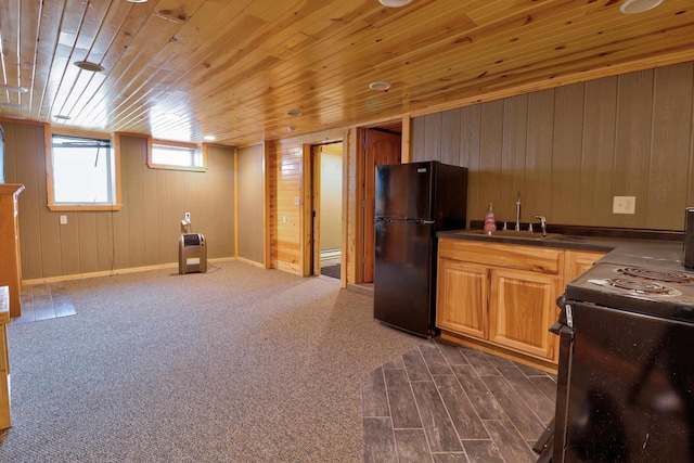 kitchen featuring black appliances, wood walls, wood ceiling, and sink