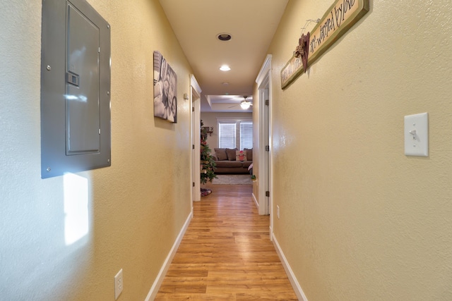 corridor featuring light wood-type flooring and electric panel